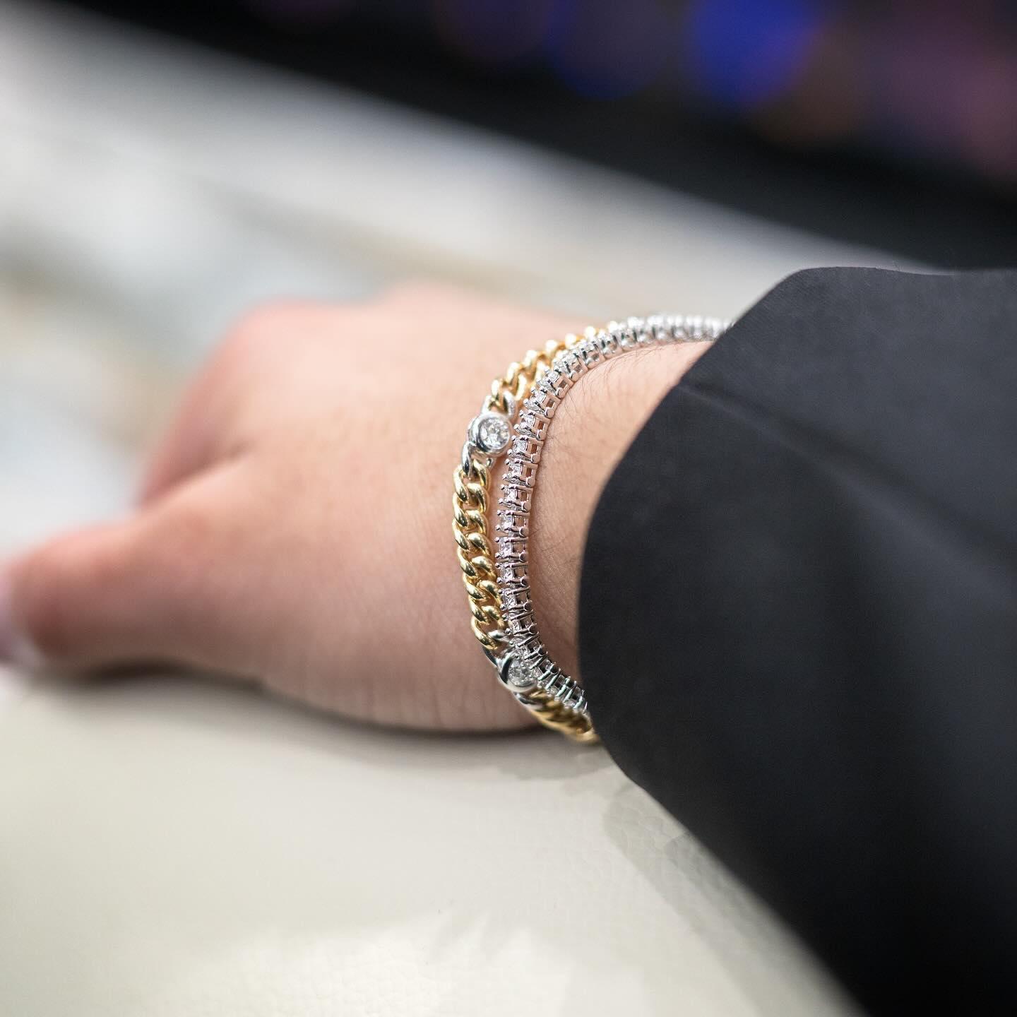 Two-tone diamond and gold bracelets layered on a wrist